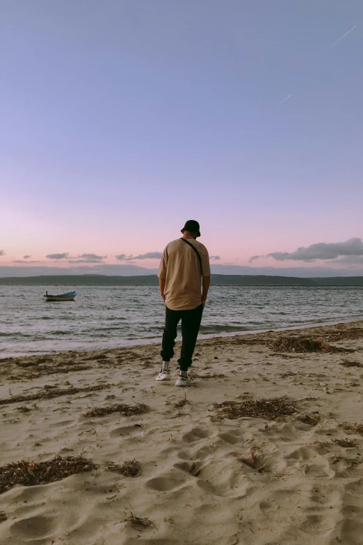 man standing at the ocean looking to the sky