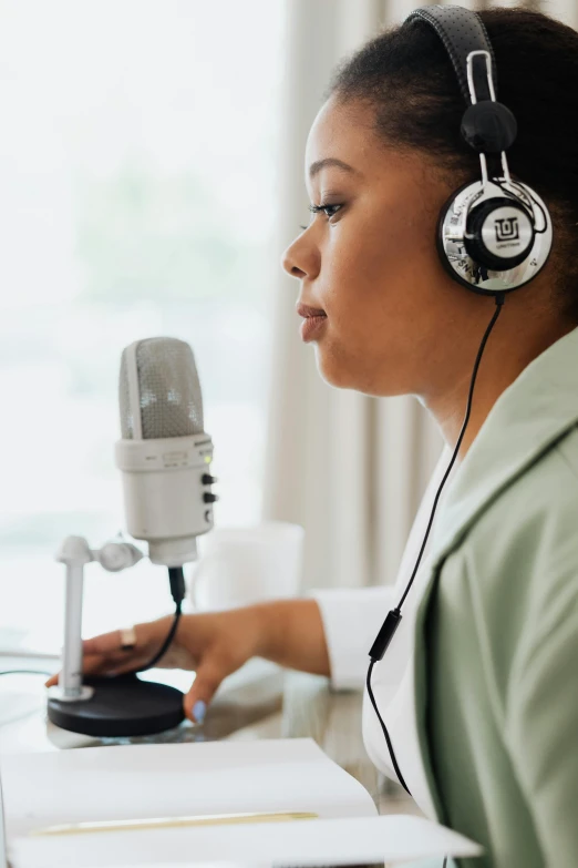 a female with earphones on is typing while wearing headphones