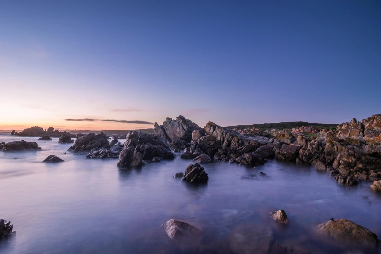 a small lighthouse on the rocks of a beach