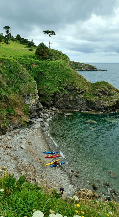 there is several small boats sitting on the shore by the water