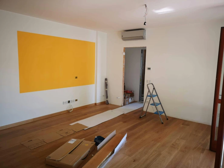 a ladder stands in the middle of an empty room