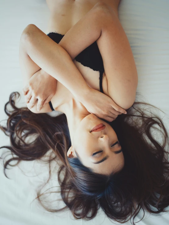 a woman in lingerie lays on her back