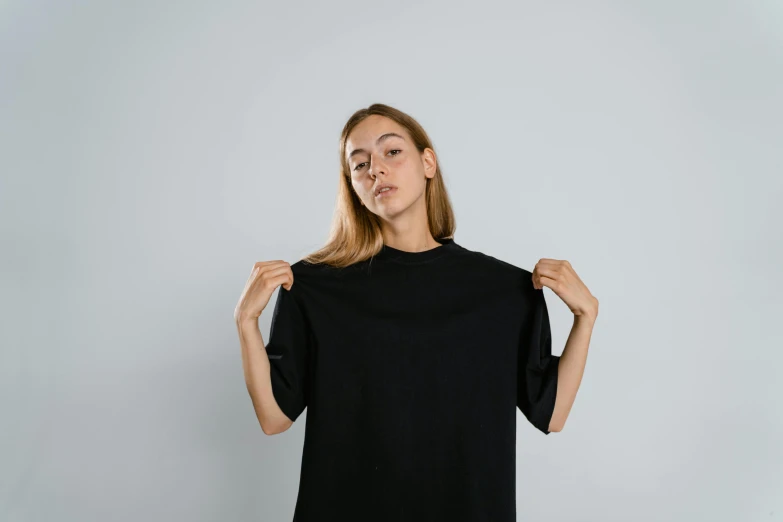 woman in black shirt holding up a black t - shirt