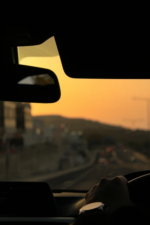 a sunset view out a vehicle window on a highway