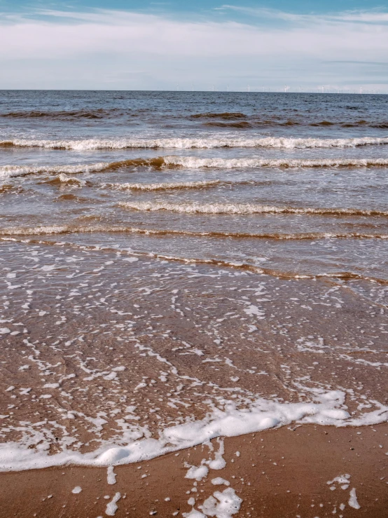 there is a surfboard at the edge of the ocean