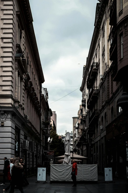 an old man is walking down a narrow street