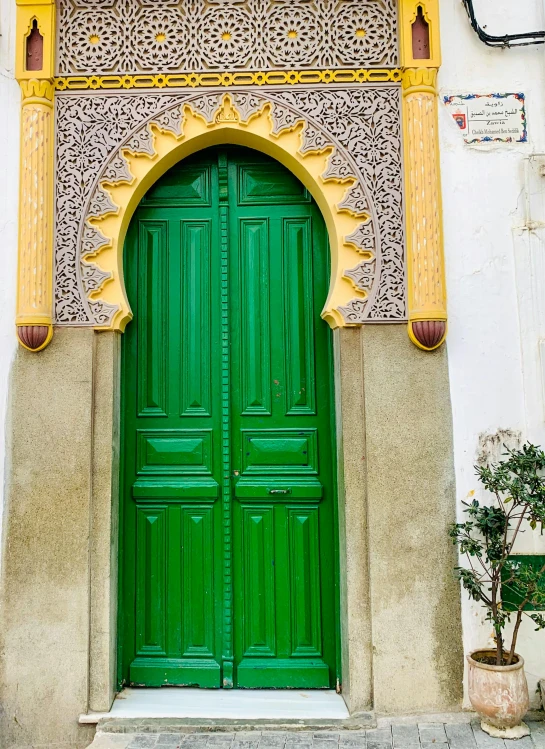 a green door with carvings on the upper part