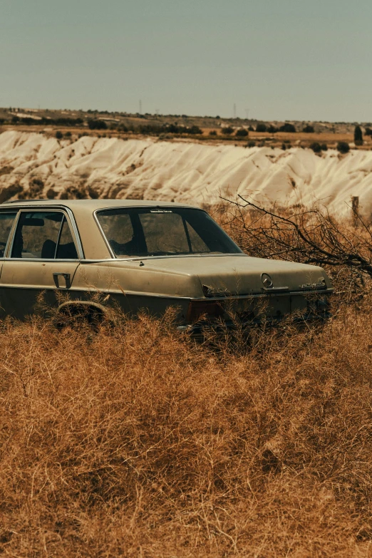 a car is sitting in an old brown field