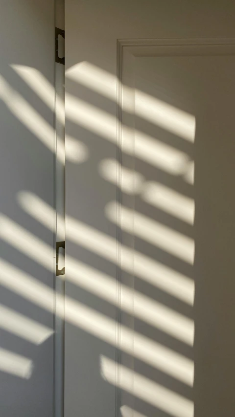 a shadow of a wall and door is projected by sunlight coming through the window