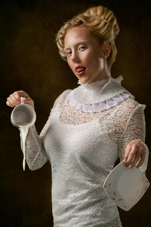 a woman holding a cup and saucer with a spoon