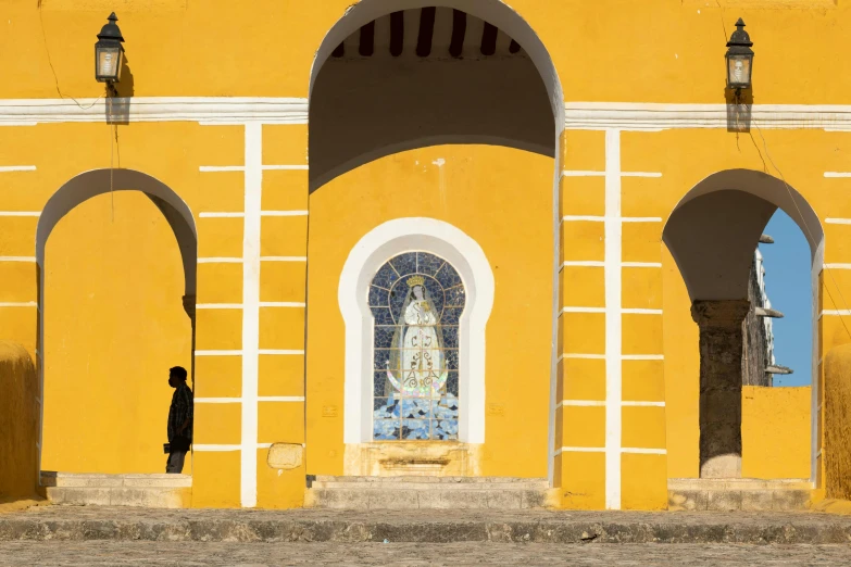 a yellow building with an arched doorway and large window