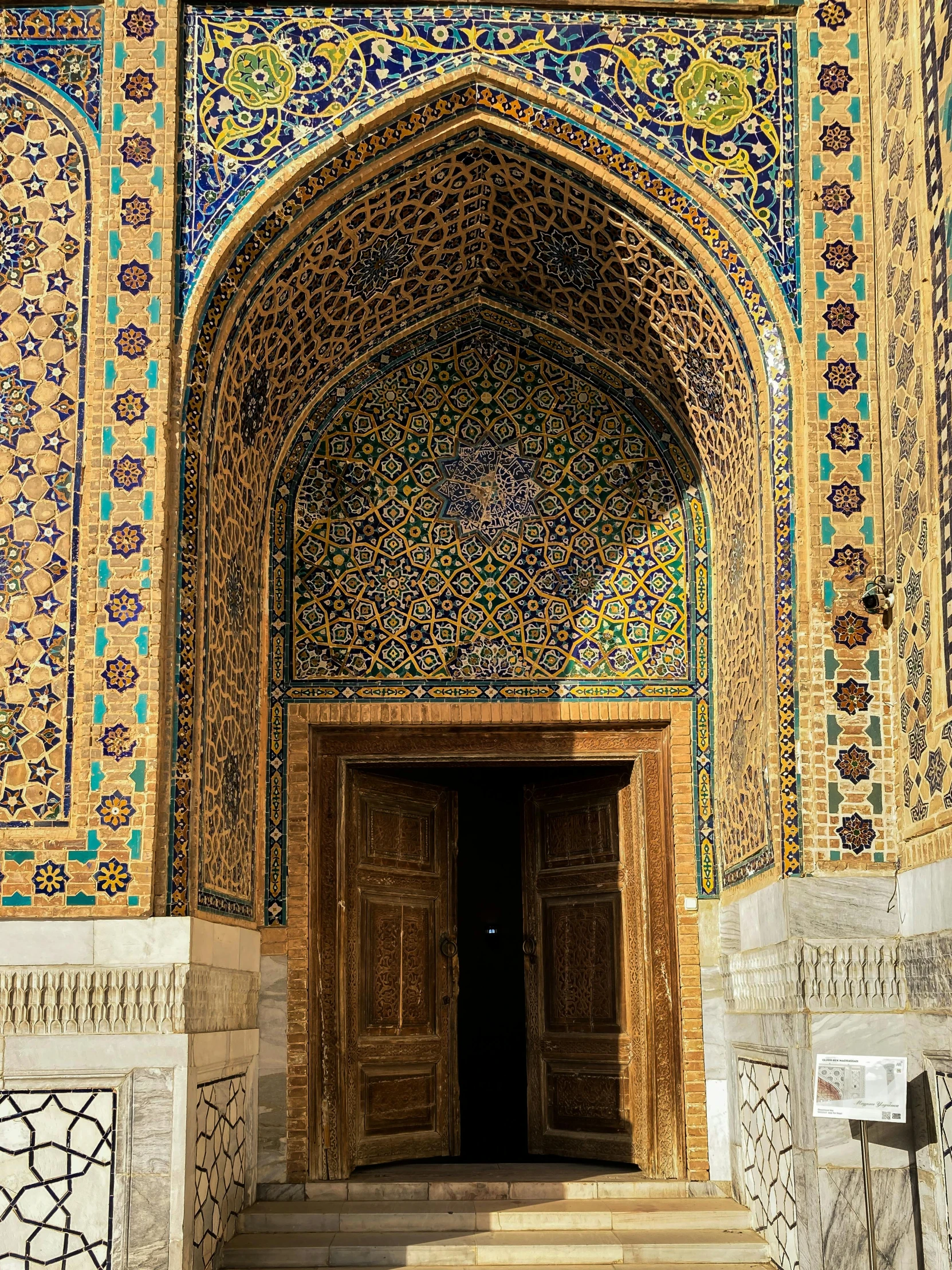 the door to the entrance to a building with colorful tile work