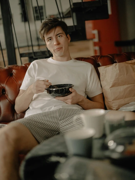 a man is sitting on the couch with coffee