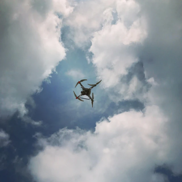 an airplane flying through a cloudy blue sky