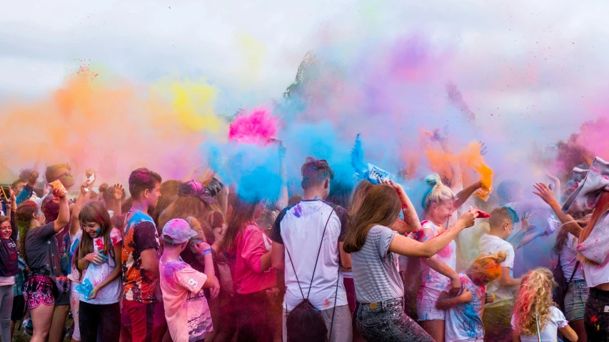 a bunch of people that are playing with colored powder