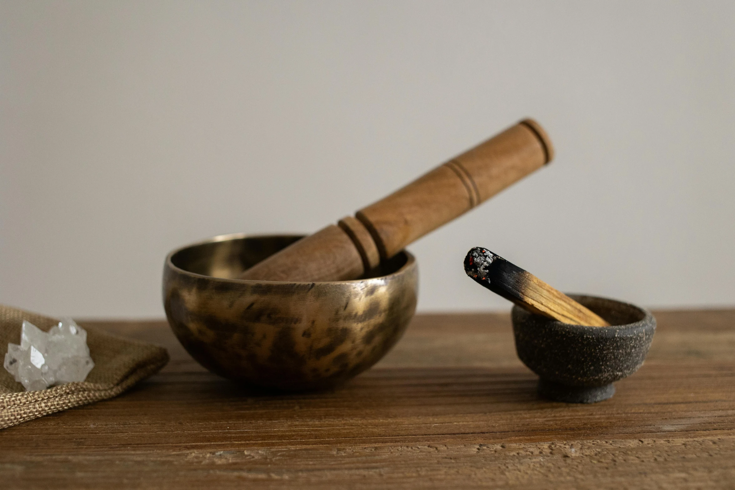 a small bowl that has an old fashioned wooden handle next to a mortar mortar and a small mortar in it