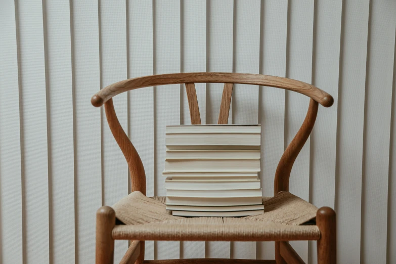 a stack of books on top of a wooden chair