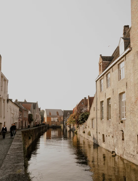 a river running next to two buildings near a road