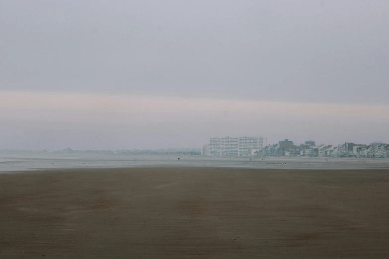 a large ship docked near the beach in the fog