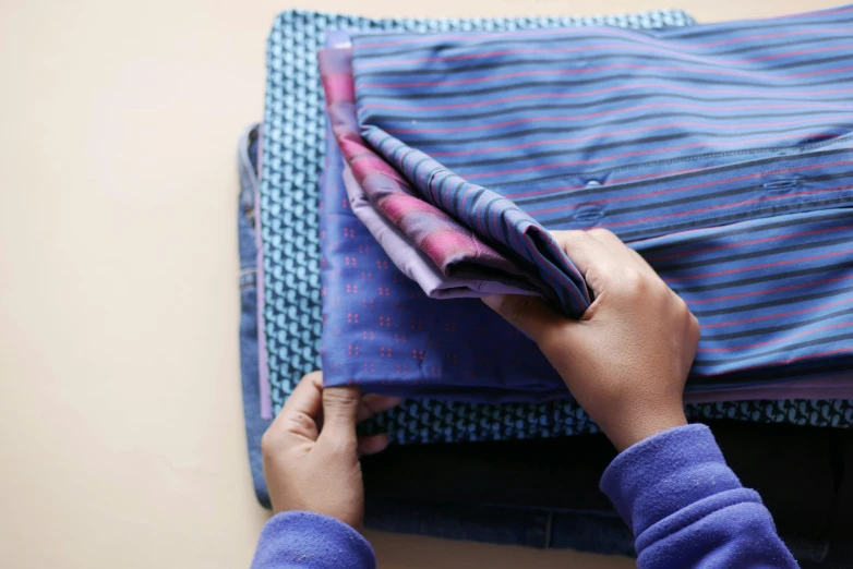 an individual is removing fabric from a piece of luggage