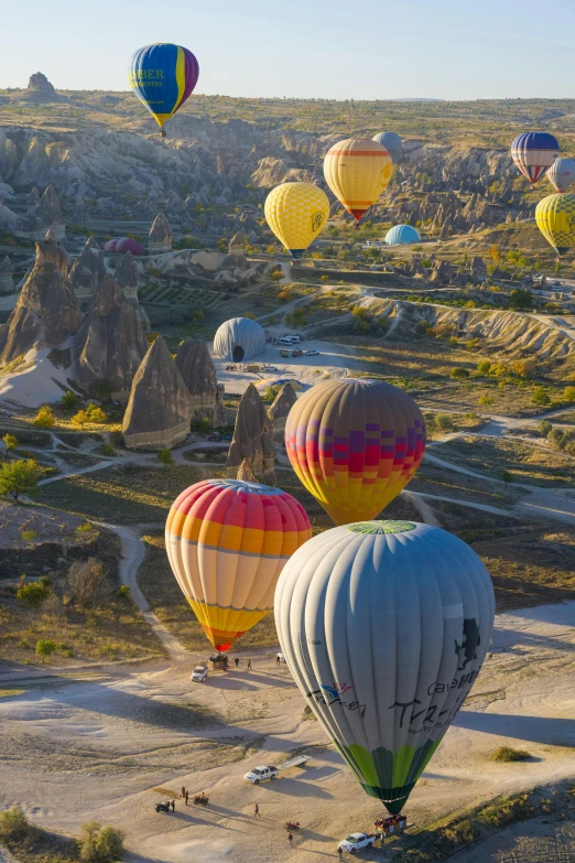 several  air balloons flying in a desert