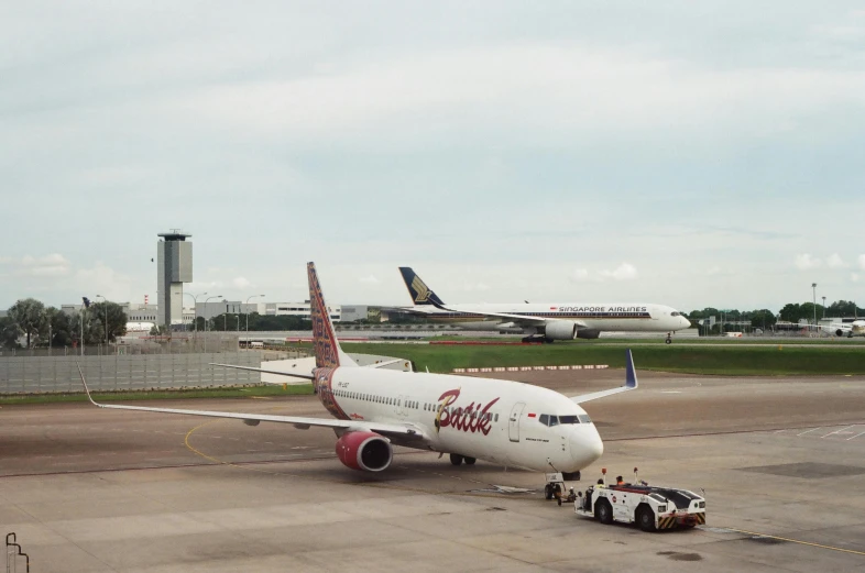 large commercial airplane parked in a lot in front of other planes