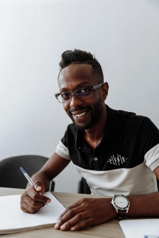 a man with glasses and a tie is smiling