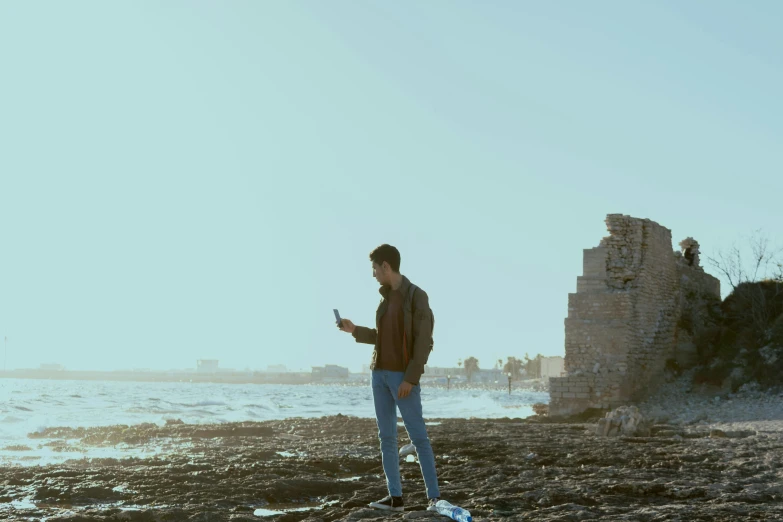 a person on a beach near the ocean and building