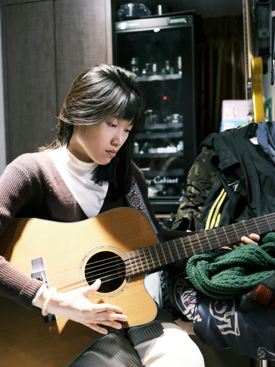 a young woman holding a guitar inside of a store