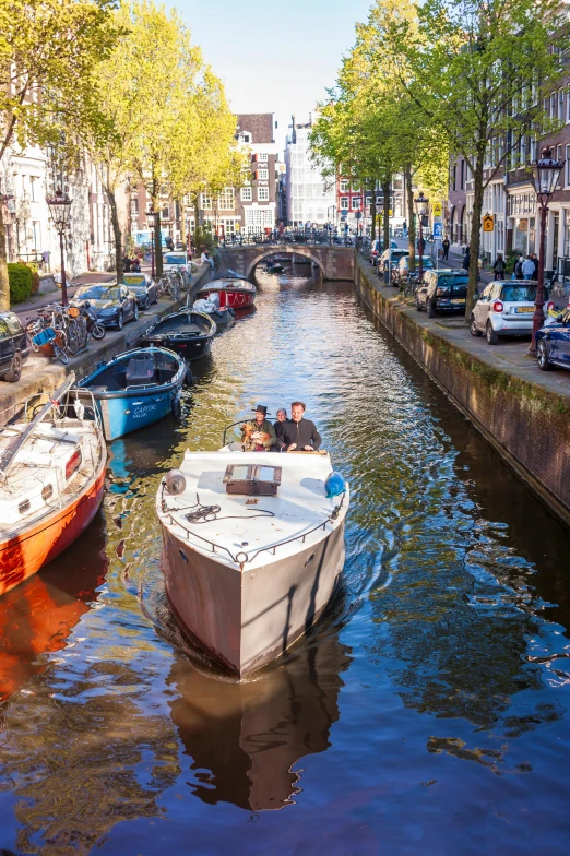 a group of boats traveling down a small canal