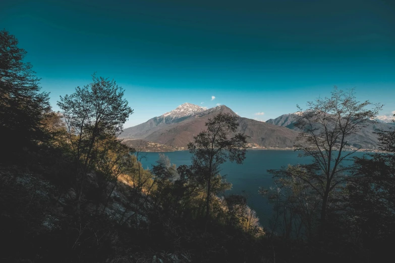 the mountains are overlooking water on a sunny day