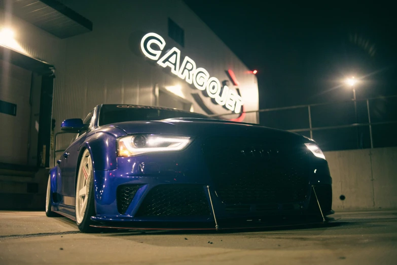 a black sports car is parked outside of a building at night