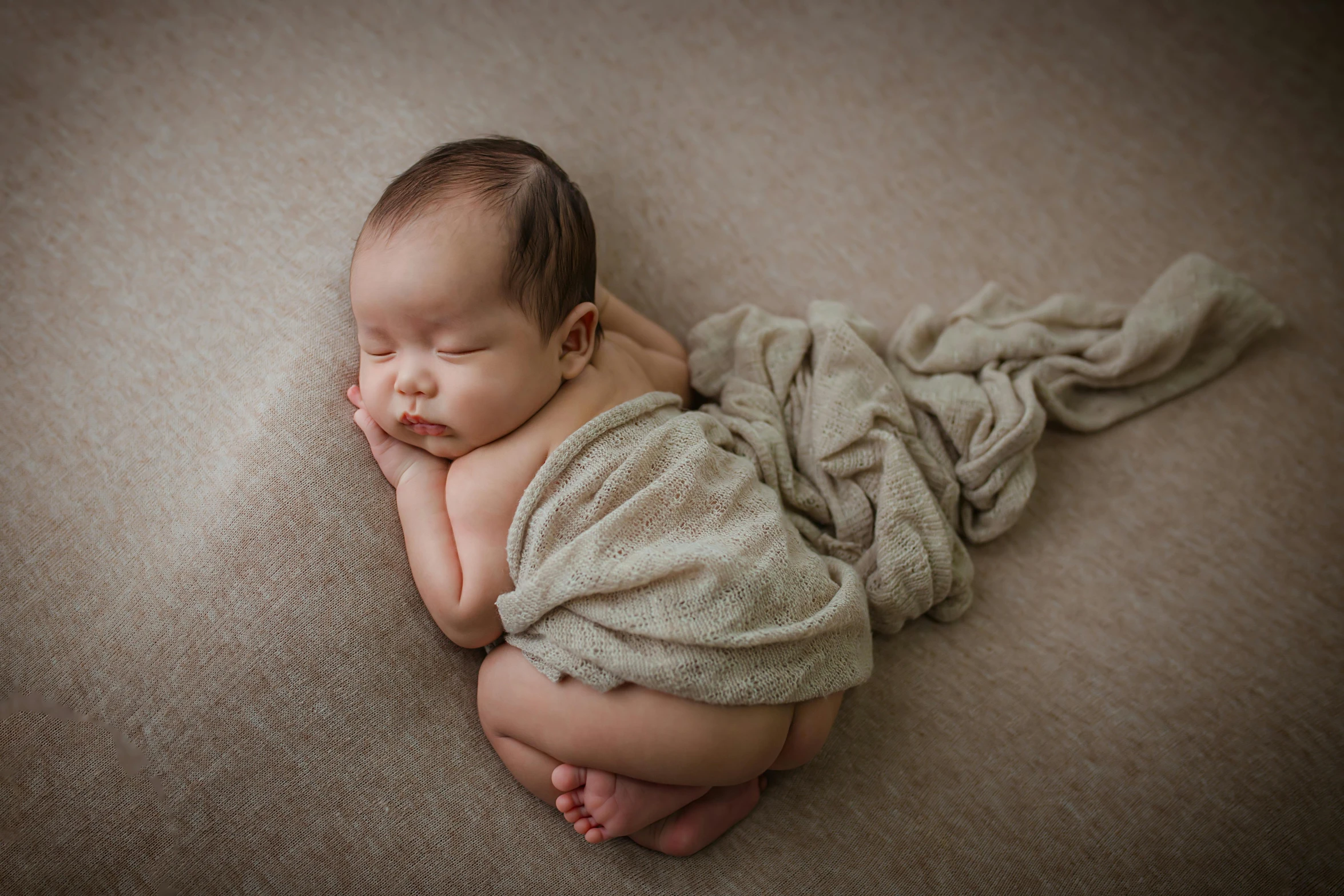 a small child sleeping in a blanket