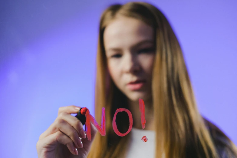 a woman holding a marker in her hands with the word no