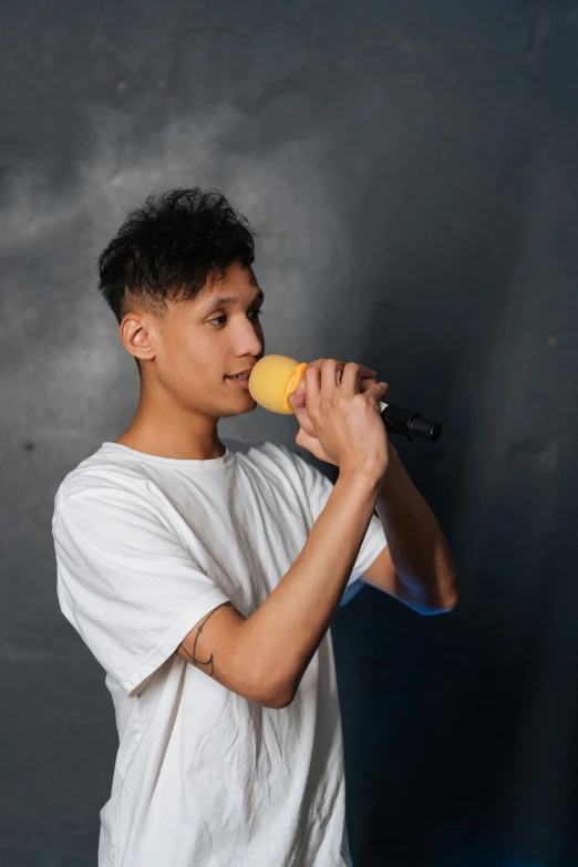 a boy drinking soing out of a yellow and black bottle