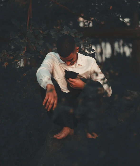 a man in white shirt and black pants holding an old cell phone