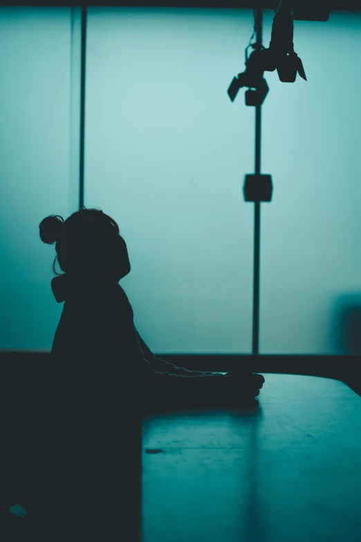 a woman in silhouette sitting at a table