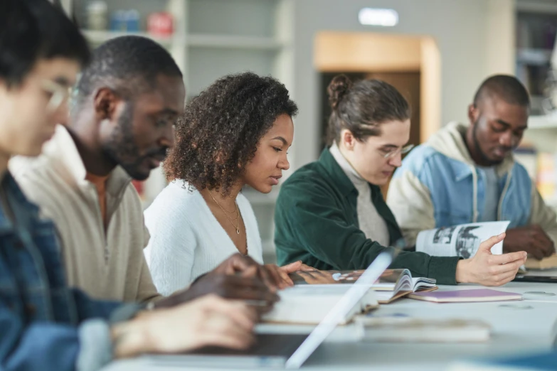 four people sitting at a table working on soing