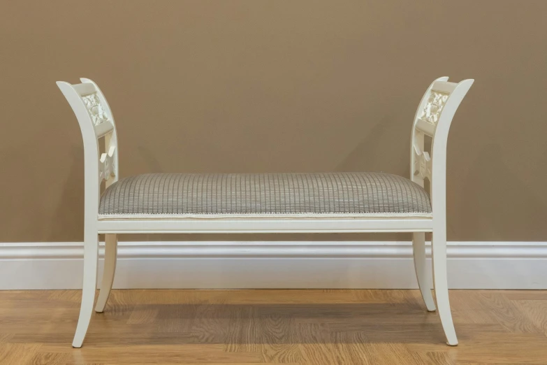 white wooden bench with padded seat against wall