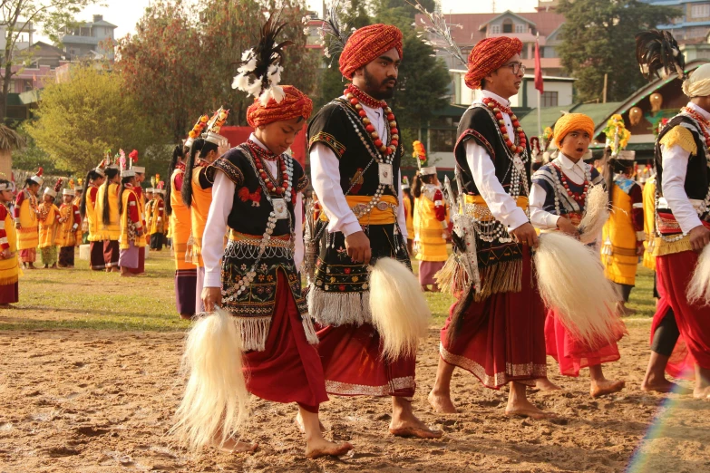 people dressed in elaborate indian garb are marching through the street