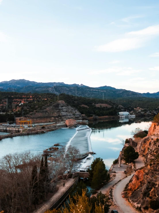 the view from a hill over water and trees