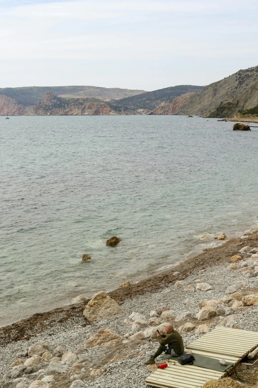 a person laying on a mat near the beach