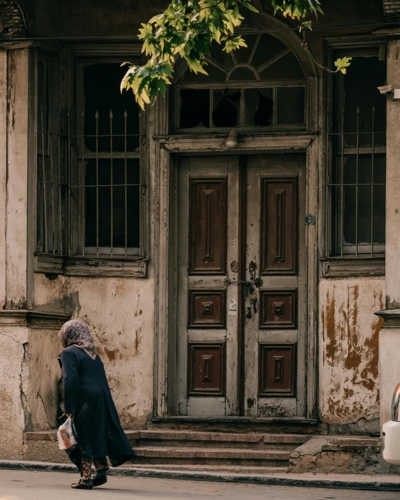 there is a woman walking by a building