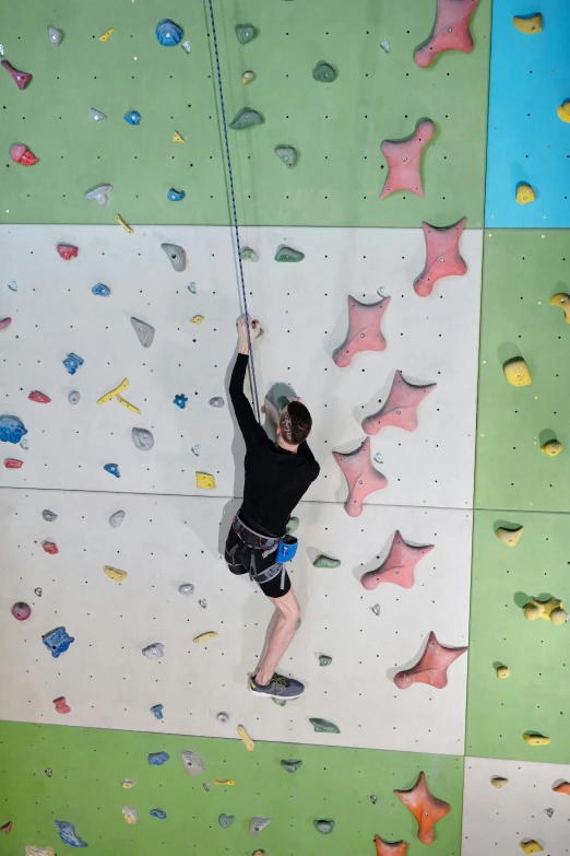 a man climbing up a very colorful wall