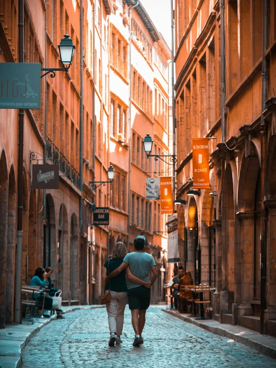 two people walking on a stone path in an alley