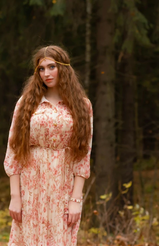 a beautiful young woman with red hair standing in a wooded area