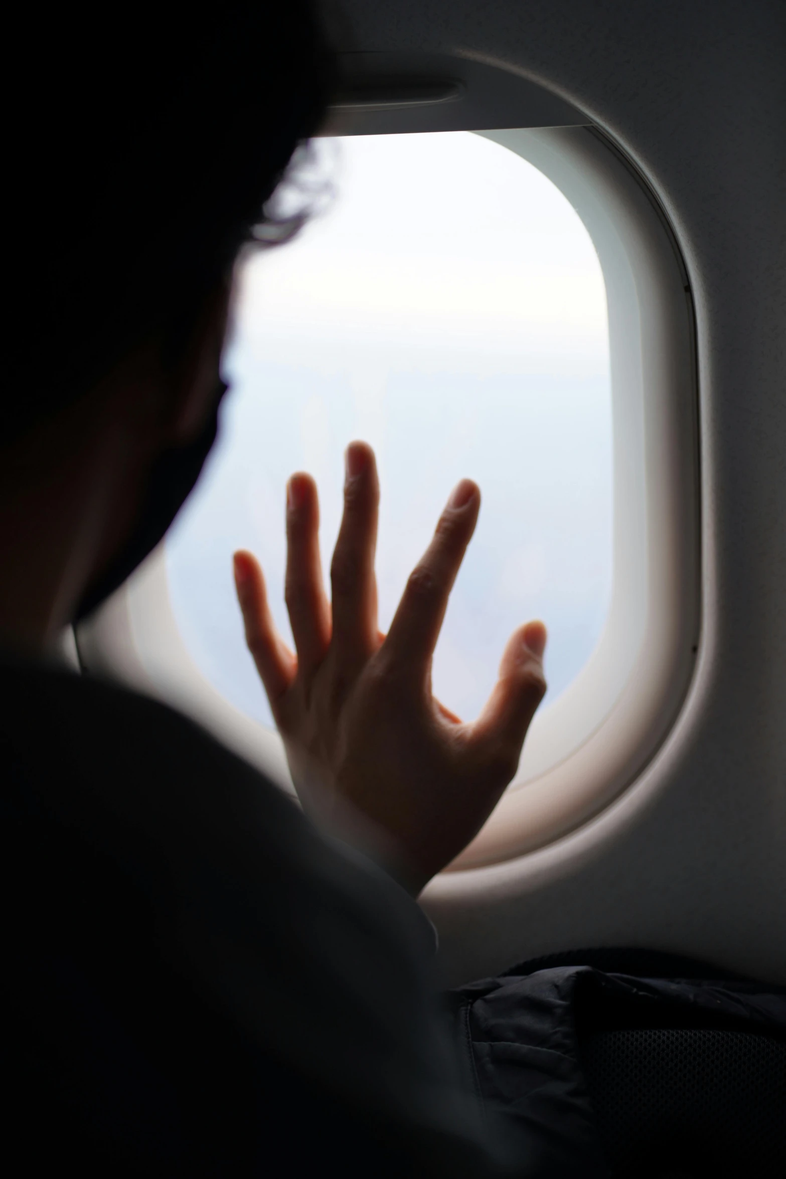 a person is pointing at a window above their head