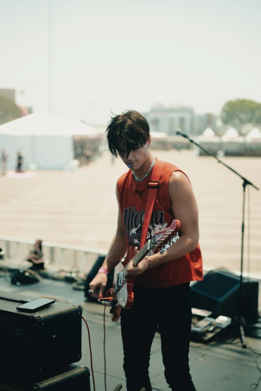 a man in an orange shirt playing guitar