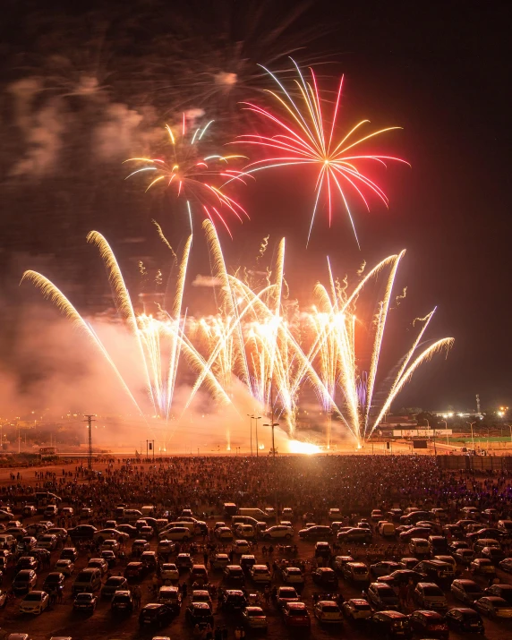 fireworks and smoke at the beach near a crowd