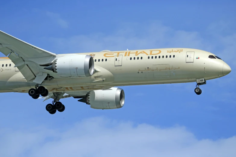 a large airplane flying through the sky with its landing gear down